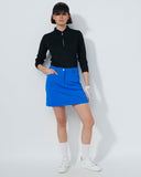 Person wearing a black top and blue skirt on a white background