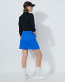 Person wearing a black jacket, blue skirt, and white shoes on a white background