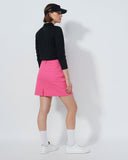 Person wearing a black top and pink skirt on a white background