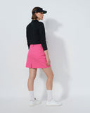 Person wearing a black top and pink skirt on a white background