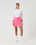 Person wearing a white shirt and pink skirt on a white background