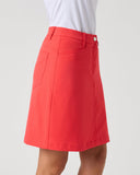 A bright coral red A-line skirt with a button closure and side pockets, shown on a model wearing a white top against a light gray background.