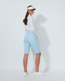 Woman wearing a white shirt, light blue pants, and a visor on a white background