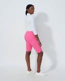 Person wearing a white long-sleeve shirt and pink shorts on a plain background