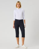 Woman wearing a white shirt and black capri pants on a light gray background