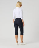 Woman wearing a white shirt and black capri pants on a plain background
