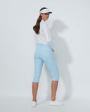 Woman wearing a white shirt, light blue pants, and a visor on a white background