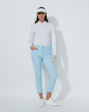 Woman in golf attire with a white shirt, light blue pants, and visor on a white background