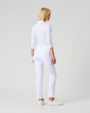 A woman with blonde hair is shown from the back wearing a white mock-neck long-sleeve top and matching white slim-fit pants, paired with white sneakers, against a light gray studio background.