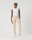 Woman wearing a white shirt and beige pants on a plain background