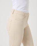 Beige pants worn with a white shirt on a light gray background