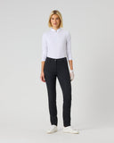 A woman modeling a white long-sleeve polo shirt and black slim-fit trousers, standing against a light gray studio background.