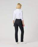 A woman is shown from behind wearing black slim-fit trousers, a white long-sleeve top, and white sneakers against a light gray studio background.