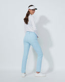 Woman wearing a white shirt, light blue pants, and a visor on a white background