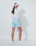 Woman wearing a white shirt, light blue shorts, and a visor on a white background