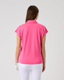 Woman wearing a pink polo shirt and white pants on a light gray background