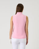 Woman wearing a pink sleeveless top and white pants on a light gray background