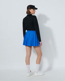 Person wearing a black top and blue pleated skirt on a white background