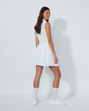 Woman wearing a white pleated skirt on a plain background