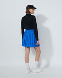 Person wearing a black top and blue skirt on a white background