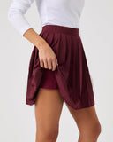 Burgundy skirt worn by a person on a plain background