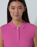Woman wearing a pink sleeveless blouse against a plain background