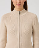 Beige ribbed knit sweater worn by a person on a light gray background