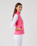 Woman wearing a pink vest over a white shirt on a light gray background
