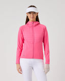 Woman wearing a pink jacket and white pants on a gray background