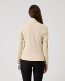 Woman wearing a beige cardigan on a light gray background