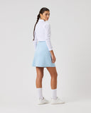 Person wearing a white long-sleeve shirt and light blue skirt on a white background