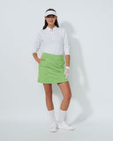 Person wearing a white shirt, green skirt, and white shoes on a white background