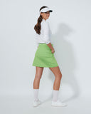 Person wearing a white shirt, green skirt, and visor on a white background