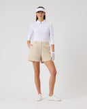 Person wearing a white polo shirt, beige shorts, and a visor on a light gray background