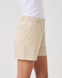 Beige shorts worn by a person on a light gray background