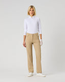 A woman modeling a white long-sleeve polo shirt and beige straight-leg trousers, standing against a light gray studio background.