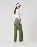 Woman wearing green pants and a white shirt on a white background