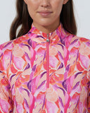 Woman wearing a colorful floral-patterned jacket on a plain background
