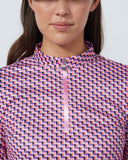 Person wearing a patterned long-sleeve shirt against a plain background