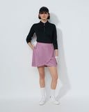 Person wearing a black top, pink skirt, and white shoes on a white background