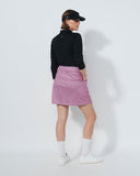 Person wearing a black jacket, pink checkered skirt, and white sneakers on a white background