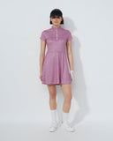 Woman wearing a pink checkered dress with white shoes on a white background