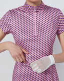 Person wearing a patterned dress with a white glove on a plain background