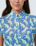 Woman wearing a patterned shirt with a plain background