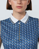 Woman wearing a blue patterned sleeveless top with a white collar against a plain background