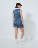 Person wearing a blue patterned dress and black visor on a white background