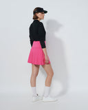 Person wearing a black long-sleeve top, pink skirt, white socks, and black shoes on a white background