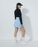 Person wearing a black jacket, light blue skirt, and white shoes on a white background