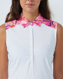 Woman wearing a white sleeveless top with a colorful floral collar against a plain background