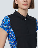 Woman wearing a black and blue patterned sleeveless top on a white background